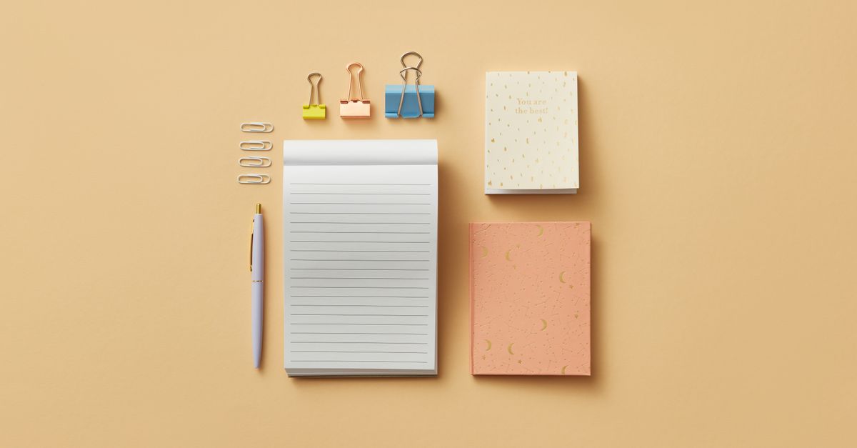 A minimalist flat lay of office supplies on a beige background, including notepads and clips.